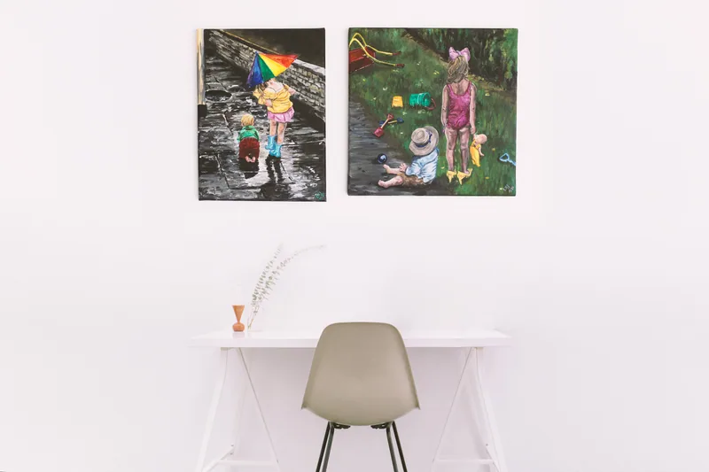 Two Pure Palette paintings hanging above a white desk